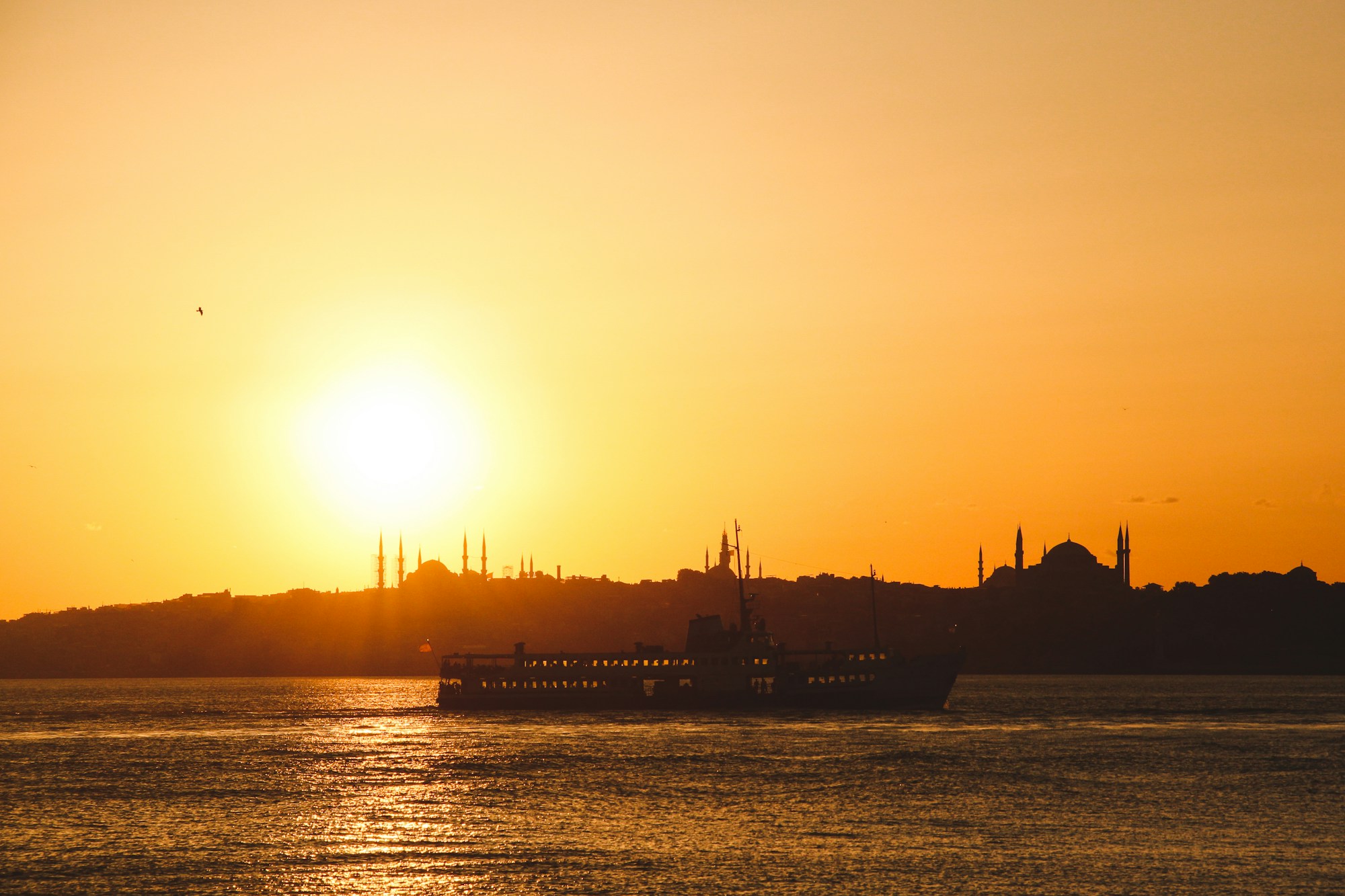 Istanbul skyline and a ferry on the Bosphorus at sunset.
